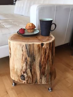 a table made out of a tree stump with a plate of food on it next to a coffee cup