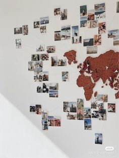 a world map made out of photos hanging on a wall