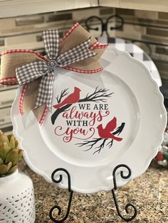 a white plate with a red bird on it that says we are always with you