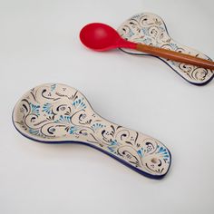 two ceramic spoons with designs on them, one is red and the other is blue