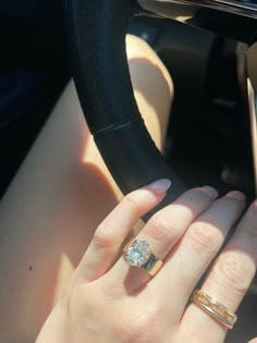 a woman with two rings on her fingers in a car