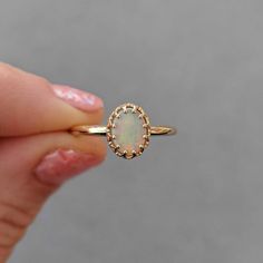 This antique style crown ring comes with a gorgeous Australian oval opal. If you want a different stone or want to add accent diamonds contact us for a quote. Details: - Default stone size is 7x5mm Australian Opal in oval shape. - Shiny finish by default. - Default width is 1.8mm at the bottom and 8.7x6.5mm at the top - Default thickness is 1.6mm at the bottom and 2mm at the top. - Contact us for quote if you want to customize this ring in any way. Thank you for shopping with Sevgi Jewelry! Oval Opal Halo Ring In 14k Gold, 14k Gold Oval Cabochon Opal Ring For Anniversary, Classic 14k Gold Opal Ring With Halo, Heirloom 14k Gold Opal Ring Oval Cabochon, Oval Opal Ring With Prong Setting In 14k Gold, Elegant 14k Gold Oval Opal Ring, Elegant Oval Opal Ring In 14k Gold, Heirloom Opal Rings With Oval Shape, Heirloom Opal Oval Rings