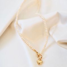 This necklace features a brass puff heart, gold-filled clasp, and freshwater pearls, all of which come together to form a beautiful and unique piece. Length: 16" Pearl Heart Necklace, Pearl Heart, Puffed Heart, Freshwater Pearl Necklace, Freshwater Pearl Necklaces, Heart Jewelry, Heart Necklace, The United States, Fresh Water