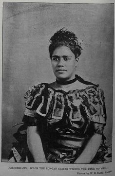 an old black and white photo of a woman wearing a dress with letters on it