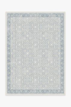 a light blue and white rug with an intricate design on the bottom, in front of a