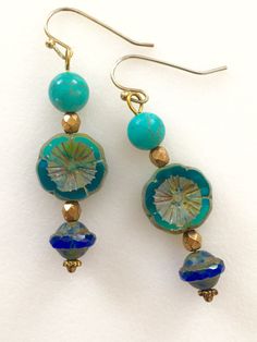 "Lightweight earrings handmade of semi-transparent aqua blue Czech glass Picasso flower, 8mm turquoise howlite, and cobalt blue Picasso UFO bead. Accented with light bronze Czech glass beads and gold wire. Earrings come on simple gold plated fish hook ear wires, lead and nickel free. Measure 2 1/8\"'long from top of ear wire." Nickel Free Czech Glass Flower Earrings, Blue Round Beaded Earrings With Spacer Beads, Turquoise Czech Glass Jewelry With Spacer Beads, Turquoise Czech Glass Round Beads Jewelry, Turquoise Czech Glass Bead Jewelry, Turquoise Glass Earrings For Gift, Blue Round Beaded Earrings For Gift, Blue Round Beaded Earrings As Gift, Blue Beaded Earrings For Gifts