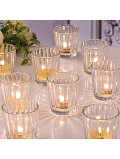 candles are lit in glass bowls on a table