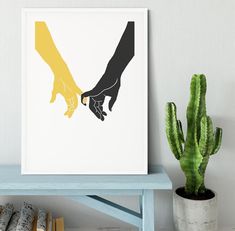 two hands holding each other's hand in front of a cactus