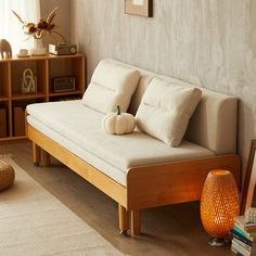 a living room with a white couch and bookshelf in the corner next to a window