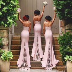 three women in pink dresses standing on steps with their hands up to the sky and holding flowers