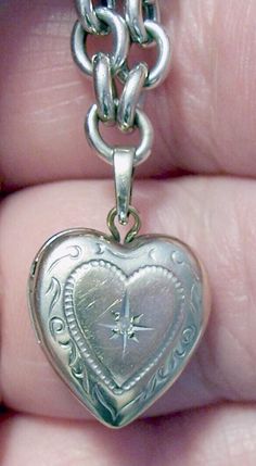 ~ Vintage 14K white gold heart locket on a 14K white gold bracelet - locket measures almost .5" tall and .5" wide at the widest point - it has a moissanite center stone inside a star and a lovely scroll design - inside are two sides for tiny photos - it closes securely. ~ Looking closely, it is etched with names on the reverse that have faded with time - it reads "Kelci and Dougie" - could possibly be buffed out - it is also hallmarked "14K" and "Tk" - the "T" and the "k" are conjoined and are t White Gold Heart Charm Bracelet For Anniversary, White Gold Heart Bracelet With Charm For Anniversary, Victorian Heart Charm Jewelry For Formal Occasions, Vintage Heart Charm Jewelry For Formal Occasions, Heart Cut Jewelry For Valentine's Day Collectibles, Collectible Heart Cut Jewelry For Valentine's Day, Heart Cut Collectible Jewelry For Valentine's Day, Victorian 14k Gold Jewelry For Valentine's Day, Antique Heart-shaped Jewelry For Formal Occasions