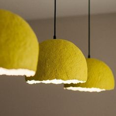 three yellow lamps hanging from a ceiling in a room