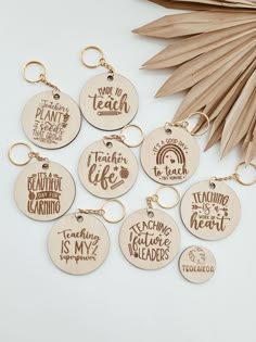 six wooden keychains with different sayings on them next to a palm leaf