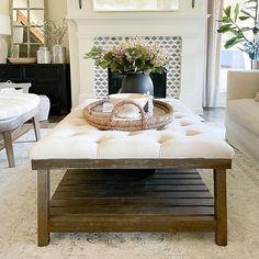 a living room filled with furniture and a large painting on the wall above it's fireplace