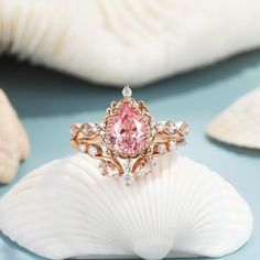 a pink diamond ring sitting on top of a shell