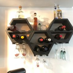 a wall mounted wine rack filled with bottles and glasses