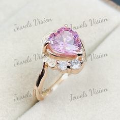 a pink heart shaped ring with three diamonds