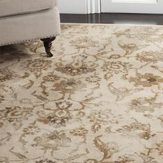 a beige rug with an ornate design on the floor in front of a white door