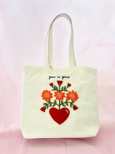 a white bag with red flowers and a heart on it