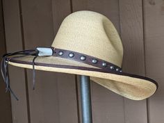 The Elsa Gus Palm hat has a golden hue. The brim is trimmed in brown grosgrain. Distressed leather has been simply decorated and the back has a deer antler bead. The brim measures 4" and the crown is 5 1/2". It's a very soft and comfortable hat. Note: Please allow 3-4 weeks. Brown Curved Brim Hat Bands For Kentucky Derby, Adjustable High Crown Felt Hat In Country Style, Brown Hat For Kentucky Derby And Ranch Events, Elegant Brown Hat Bands For Rodeo, High Crown Brown Country Hat, Brown High Crown Country Hat, Brown High Crown Fedora For Country Events, Rustic Style Hat Bands For Kentucky Derby, Rustic Brimmed Hat Band For Kentucky Derby