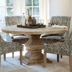 a dining room table with leopard print chairs and a tray on it's center