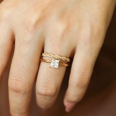 a woman's hand with a gold ring on it and a diamond in the middle