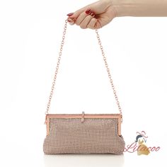 Pick this elegant handbag for your next evening event, and you'll make a stunning impression. The sophisticated rose gold frame provides a luxurious backdrop for the shimmering rhinestones that cover the entire exterior, creating a brilliant, eye-catching design. The handbag's sleek, rectangular shape is both modern and timeless, ensuring it will complement a variety of outfits. The top closure features a sparkling jeweled clasp, adding an extra touch of glamour and keeping your belongings secur Gold Evening Bag With Gold-tone Hardware, Luxury Rectangular Evening Bag With Gold-tone Hardware, Metallic Evening Bag With Gold-tone Hardware, Gold Hand-embellished Rectangular Evening Bag, Glamorous Gold-tone Hardware Evening Bag, Rhinestone Clutch, Rose Gold Frame, Frame Bag, Square Bag