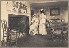 two women standing in front of a fire place