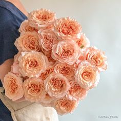 a woman holding a bouquet of pink roses