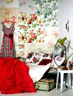 a bed room with a neatly made bed and flowers on the wall next to it