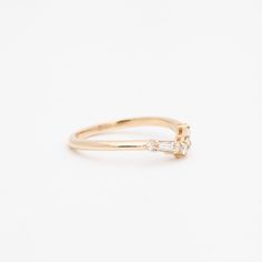 Simple, elegant, and designed to flatter—not overwhelm—your other rings, this gently curved band always feels like a perfect fit. Stack a pair of each side of your solitaire for a gorgeous frame of diamonds or pair it with an east-west cocktail ring to give your chunkiest gems a dainty finish. Made in the U.S.A. 14 karat gold set with five round white diamonds and two baguette white diamonds totaling 0.20 carat. Classic Stackable Baguette Cut Cubic Zirconia Rings, Classic Open Band Wedding Ring With Single Cut Diamonds, Elegant Stackable Rings With Single Cut Diamonds, Elegant Stackable Rings With Diamond Accents, Emerald Cut, Elegant 14k Gold Baguette Cut Stackable Rings, Timeless Stackable Rings With Brilliant Cut Open Band, Elegant White Gold Stackable Rings With Baguette Cut, Classic Stackable Diamond Rings With Open Band, Classic Diamond Stackable Rings With Open Band