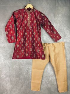 Boys Kurta Pajama Set in Raw Silk material with Cotton Lining. Kurta has Ikkat designs on the back, front and sleeves. The neckline has beautiful lace work and fancy buttons. Item : Boys Kurta PajamaReady to Wear : YesKurta Color : Maroon Kurta Fabric : Raw Silk Pajama Color : Gold Fabric : Raw Silk Pocket : YesLining (Yes/No) : Yes (Cotton Lining in Kurta)Disclaimer- There can be little variation in the color due to screen resolution setting, phone display setting or anything else. Kindly do no Kurta Pajama For Boys, Kids Indian Wear, Phone Display, Boys Kurta, Fancy Buttons, Silk Pajama, Kurta Pajama, Gold Fabric, Boys Pajamas