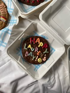 there is a chocolate cake with happy birthday written on it and two other cakes in the background