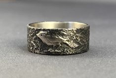 This little guy, or gal, is a cardinal. The ring is sterling with a fine silver overlay. and a patina to bring out the lovely painterly quality. These are custom made to your size and take about 2 weeks. Since I make each one by hand, no two are exactly alike. I can also work with you to create a design of your own. Contact me so we can discuss your ideas further. If you are unsure of your size, you can purchase this ring sizer. It is adjustable, tells you the size, and can be reused indefinitely. The purchase of the sizer comes with a guarantee that if it doesn't fit, it can be resized for free. See listing for more details: https://www.etsy.com/listing/94678905/ring-sizer If you would like something stamped on the inside of the ring, add this to your order: https://www.etsy.com/listing/6 Handmade Engraved Sterling Silver Ring For Formal Events, Handmade Engraved Sterling Silver Ring For Formal Occasions, Carved Sterling Silver Rings For Anniversary, Unique Carved Engraved Ring For Promise, Unique Carved Engraved Promise Ring, Hand Cast Sterling Silver Engraved Ring For Wedding, Unique Carved Rings As Gifts, Unique Carved Rings For Gifts, Heirloom Sterling Silver Hand Cast Jewelry