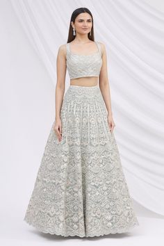 Grey lehenga with mirror and zari embroidered floral motifs. Comes with blouse and sheer dupatta.
Components: 3
Fabric: Net
Neckline: Square
Sleeve Length: Sleeveless
Color: Grey
Embroidery
Mirror and zari embroidered floral motifs on blouse
Deep back with tassel tie-up
Mirror and zari embroidered floral motifs on dupatta - Aza Fashions Grey Lehenga, Embroidered Bridal Lehenga, Sheer Dupatta, Grey Embroidery, Embroidery Mirror, Embroidered Lehenga, Bridal Lehengas, Indo Western, Bridal Lehenga