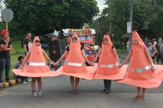 some people are holding orange cones on the street