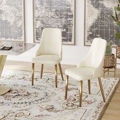 two white chairs sitting on top of a rug in front of a dining room table