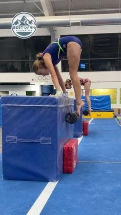 a woman in a blue swimsuit jumping over blocks