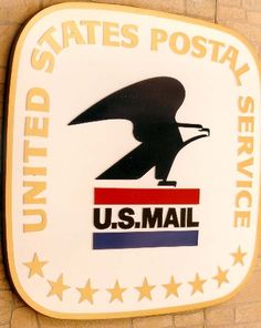 the united states postal service sign is mounted on a brick wall with stars around it