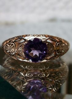 Natural Purple Amethyst Gold Ring Etched Wedding Design#160 Custom This stunning Victorian vintage reproduction ring in 10k rose gold has a brilliant natural purple amethyst gemstone. This full cut round cut genuine amethyst is 6mm in diameter. The inside of the band is marked 10k for gold. Notice the beautiful floral design of the gold filigree setting. This is a lovely rendition of an Antique filigree wedding ring. Make a spectacular statement about love and romance with this glorious solitair Elegant Amethyst Wedding Ring, Elegant Wedding Amethyst Ring, Gold Amethyst Ring With Center Stone For Wedding, Elegant Purple Amethyst Ring With Intricate Design, Vintage Oval Amethyst Ring For Wedding, Vintage Oval Amethyst Wedding Ring, Amethyst Rings With Intricate Design For Wedding, Heirloom Gold Amethyst Ring For Weddings, Gold Amethyst Ring For Wedding