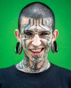 a man with tattoos and piercings on his face