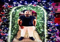 a man standing in front of a lighted archway with christmas lights on the sides and around him