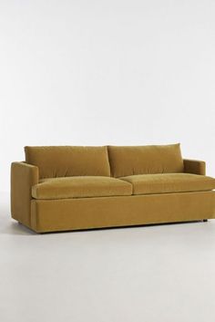 a yellow couch sitting on top of a white floor