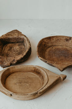 three pieces of wood sitting on top of a white table next to an empty bowl