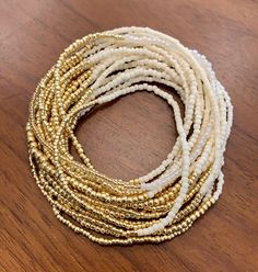 "IVORY AND GOLD Simplicity shines in this extra-long wristlace, a 2-in-1 wrap bracelet and necklace that can be worn several ways. A rich variety of bead textures, shapes, and finishes -- luminous, translucent ivory \"pearls,\" iridescent ivory tubes, shiny opaque ivory bead, matte ivory rocailles, transparent gold cubes, metallic gold beads in three shapes and sizes -- takes this simple two-color item to the next level, a beautiful, delicate piece to wear with everything. . Custom sizing, made Gold Wrap Bracelet With Tiny Beads As A Gift, Gold Jewelry With Tiny Beads For Layering, Gold Double Strand Jewelry For Festive Occasions, Gold Double Strand Beaded Necklaces With Tiny Beads, Gold Double Strand Beaded Necklace With Tiny Beads, Gold Hand Wrapped Bracelets For Party, Hand Wrapped Gold Bracelets For Party, Gold Rondelle Bohemian Jewelry, Bohemian Gold Rondelle Jewelry