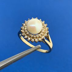 * Designer 14K Yellow Gold Pearl Solitaire Diamond Double Halo Cocktail Ring * Ring size: 7.0 * Top of ring measures: 1/2" x 1/2" * Height: 1/2" * Band width: 1.6 mm * Pearl measures approximately 7.0 mm * Diamonds measure approximately between .80 mm and 1.1 mm each * Ring weight: 3.2 tgw * Marked: MAKERS MARK * 14K * Ring can be resized for an additional fee. * G3428    Exported By ExportYourStore :) Pearl And Diamond Ring Vintage, Yellow Gold Cluster Jewelry With Halo Setting, Elegant Gold Cluster Birthstone Ring, Classic Cluster Halo Ring, Gold Pearl Ring With Halo, Classic Diamond Pearl Ring Hallmarked, Classic 14k Gold Pearl Open Ring, Classic 14k Gold Pearl Ring With Open Design, Yellow Gold Cluster Ring In Fine Jewelry Style