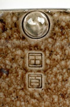 a close up of a brown and white ceramic object with two squares on the front