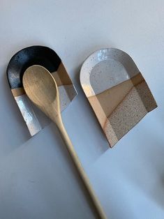 two wooden spoons sitting next to each other on top of a white countertop