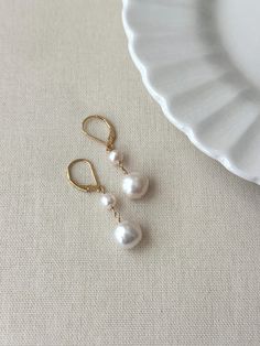 Never underestimate the power of a simple pearl drop earring! These double baroque pearl earrings look as beautiful on your special day as they do glamming up any casual outfit. They are sure to become a favorite go to accessory! * Natural 6mm and 10mm off-round white Baroque Pearls * 14K Gold Filled or 925 Sterling Silver 17mm Leverback clasp * 1.5 inch length * Made with all hypoallergenic materials 🤍 *Please note for the health and safety of my customers, and to uphold the highest quality standards - these earrings are final sale - please dm me with any questions prior to purchase 😊 ✨ Shop all Pearl earrings here!: https://etsy.me/3Xiy4c5 GET TO KNOW MAGBEE JEWELRY! ✨  🤍 All MagBee pieces are safe for sensitive skin and made with hypoallergenic Gold Filled or 925 Sterling Silver. 🤍 Dangly Earring, Simple Pearl Earrings, Bridal Pearl Earrings, Pearl Drop Earrings Bridal, Drop Earrings Bridal, Pearl Earrings Gold, Freshwater Pearl Drop Earrings, Earrings Double, Simple Pearl