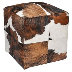 an animal print cube ottoman is shown in brown, white and black colors on the top